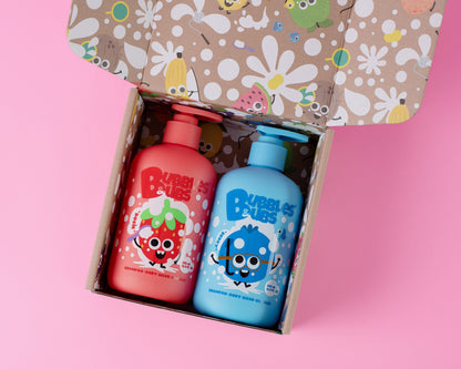 Two bottles of bubbles and bubs shampoo, body wash and bath bubbles in presented in an open gift box with a playful pattern.playful box, Rosie the watermelon and Berry the blueberry playful character designs, 